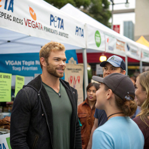 Kellan Lutz at a vegan food festival. Standing near a PETA booth with a group of activists.