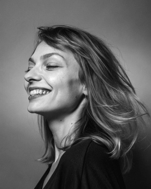 A   white beautiful WOMEN SMILES ON A GRAY MONOCHROME BACKGROUND