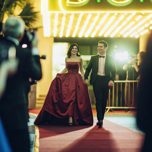 Gia Francesca Lopez and Mario Lopez walking the blue carpet at premiere of 'The Nutcracker'. Neon lights in background.