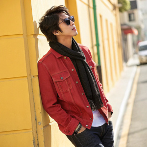 Jung Yonghwa, male, in a casual outfit. Dark brown hair, red denim jacket, black scarf. Poses against a bright, sunny street backdrop.