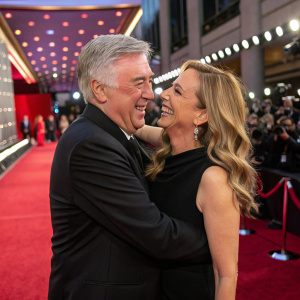 Carlo Ancelotti and Mariann Barrena McClay sharing a warm hug at the awards ceremony. Red carpet background