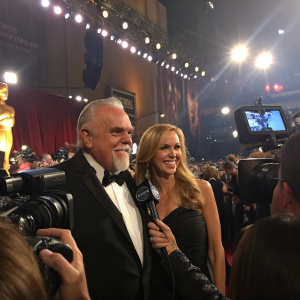 John Ratzenberger and Julie Blichfeldt at the award ceremony, standing amidst flashing cameras and a sea of reporters.