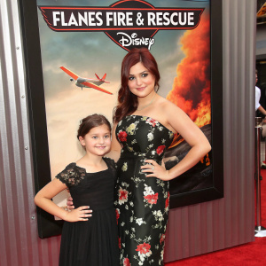 Actress Ariel Winter and a young friend at the 'Planes: Fire & Rescue' premiere. Wearing black floral gown and long black dress. Disney promotional poster in the background.