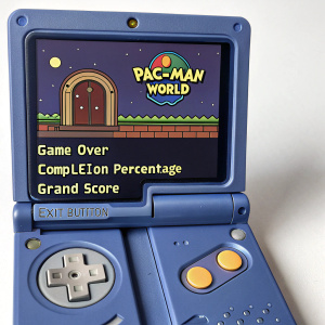 Screenshot of Game Boy Advance SP featuring Pac-Man World. End screen displays Game Over, Completion Percentage, Grand Score, and Exit Button.