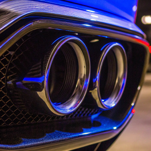 Close-up shot of Bugatti Chiron Pur Sport's rear. Sleek, streamlined body highlighted. Symmetrical exhaust pipes with black and silver finish. Modern design and precision engineering evident