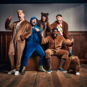 Scott Hoying, Mitch Grassi, Kirstin Maldonado, Kevin Olusola, and Matt Sallee, all dressed in quirky Halloween costumes, posing for a playful group photo at a studio.
