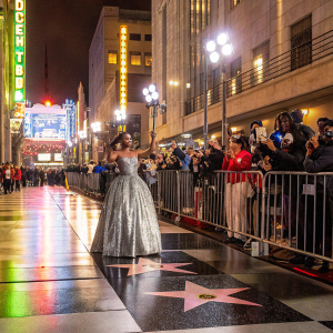 Marsai Martin at the Hollywood Walk of Fame. Dressed in a shiny silver sequined gown, posing for the camera amidst flashing lights and fans.