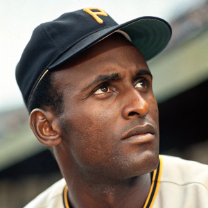 Close-up portrait of Roberto Clemente, iconic baseball player. Serious expression, dark skin, and short curly hair.