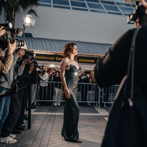 Cobie Smulders in a dazzling emerald green dress, at a Hollywood film festival. Crowded outdoor event, paparazzi flashing cameras