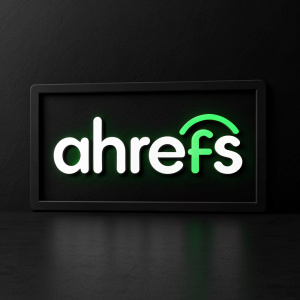 Modern, sleek logo of 'ahrefs' displayed in a clean, white sans-serif font. Bright green accents. Against a stark black background.
