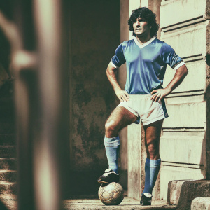 Black and white photo of Diego Maradona in his prime, wearing the iconic blue jersey of Argentina.