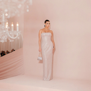 Adriana Lima at the MET Gala. She's wearing a sparkling silver gown. She looks stern.
