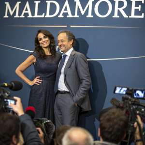 Maria Grazia Cucinotta and Giulio Violati attending a press conference for 'Maldamore'. Dark blue backdrop with bold white text
