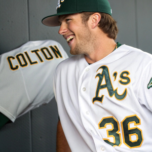 Colton Gordon, baseball player, in white jersey with '36' and team logo. Grinning confidently. Gray backdrop, close-up shot.