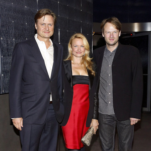 Bill Pullman, Johanna Day, and Dallas Roberts at a glamorous Hollywood event. Bill Pullman in a tailored navy suit, Johanna Day in a stunning red dress, and Dallas Roberts in a chic blazer.