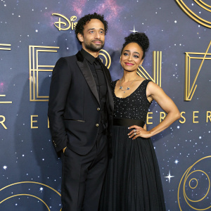 Douglas Ridloff and Lauren Ridloff, dressed in formal attire, posing at the UK premiere of 'The Eternals'. The backdrop features a celestial theme with twinkling stars and planets.