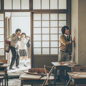 Characters from Danganronpa in a chaotic classroom scene. Background is a detailed school corridor. Each character has distinct anime-like expressions and postures.