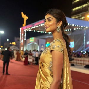 Pooja Hegde at the Bollywood Film Awards. She's wearing a golden silk saree with detailed embroidery. Background is bustling outdoor award ceremony with lights and stage