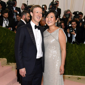 Mark Zuckerberg and Priscilla Chan at the Met Gala. Priscilla in a silver sequined gown, Mark in a tuxedo. Crowded event with paparazzi flashing cameras