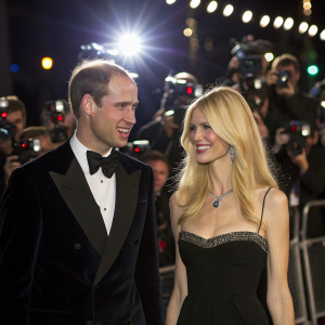Prince William and Claudia Schiffer at a high-profile charity gala. Dazzling lights and paparazzi in the background.