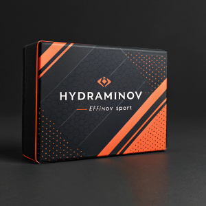Premium packaging design for Hydraminov by EFFINov Sport. Dark black background with bold orange accents. Sleek and modern, minimalist style. Prominent display of brand name 'Hydraminov' and product details in French text.
