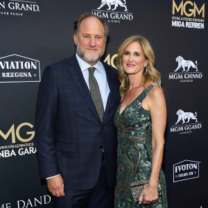 Jon Turteltaub and Amy Eldon at the MGM Grand Garden Arena event. Dark backdrop with sponsor logos.