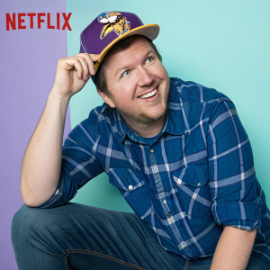 Nick Swardson, with a friendly smile, donning a blue plaid shirt and Minnesota Vikings hat. Candid pose against a bright, pastel background. Netflix logo visible.