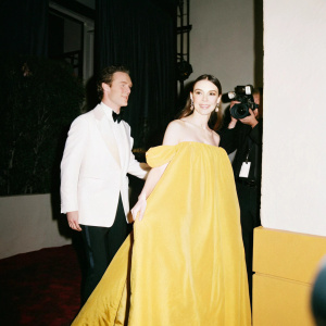 Benedict Cumberbatch and Keira Knightley attending a glitzy Hollywood awards show. Paparazzi flashlights brighten the scene.