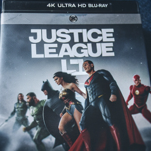 High-definition 4K Ultra HD Blu-ray cover showcasing the ensemble cast of Justice League. The image features Superman, Wonder Woman, Batman, The Flash, and other heroes in dynamic action poses. Their distinctive costumes and heroic stances are clearly visible against a dramatic backdrop. The packaging design is eye-catching, with characters and text prominently identifying the movie as Justice League and the format as 4K Ultra HD Blu-ray.