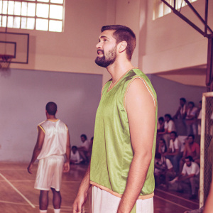Marc Gasol, bearded, short hair, in a vibrant green jersey. Crowded basketball court in the background.