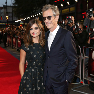 Jenna Coleman and Peter Capaldi at a premiere event. Red carpet surrounded by flashing cameras and fans.