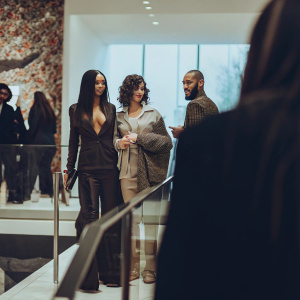 Rihanna, Monica Braithwaite, and Rajad Fenty at a glamorous PUMA launch party. The venue is a modern art gallery with vibrant installations.