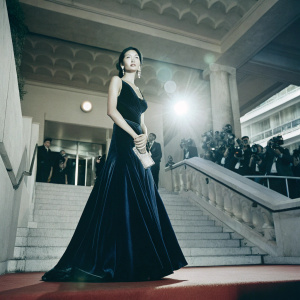 Gao Yuanyuan at Cannes Film Festival, dressed in a black velvet gown. Flashy event backdrop, red carpet crowd visible.