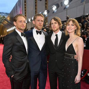 Charlie Hunnam, Fran Kranz, Max Winkler, and Jessica Barden at a glitzy awards ceremony. They're dressed in elegant evening wear. Red carpet scene with flashing cameras.