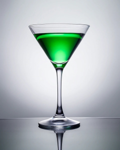 1 Cocktail glass with green alcohol on a white background