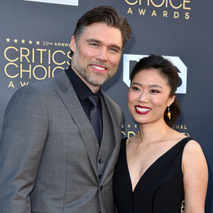 Anson Mount and Darah Trang at award show. Anson in a grey suit, Darah in a black dress.