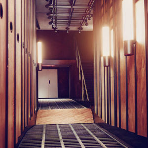 In a 3D rendering, The Forge Arena's sleek and modern design is showcased. A futuristic corridor with wood and metal flooring, illuminated by radiant overhead lamps, highlights the blend of industrial and modern elements, symbolizing cutting-edge innovation.