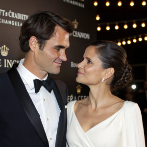 Roger Federer and Elena Anaya at Moët & Chandon Gala. Roger in formal attire, Elena in elegant white dress. Close-up shot with friendly interaction. Bright lights and Moët & Chandon backdrop