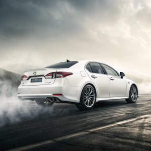 Pristine white Lexus GS 350, glowing in supernatural shine. Revealed against soft, foggy background. Unfolding rear view, like an intricate story, showcasing design elements in ethereal gray.