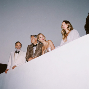 Neil Diamond, George Clooney, Katie McNeil, and Stacy Keibler at an exclusive gala. Dark, starlit sky backdrop.
