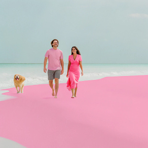 Matthew McConaughey and Camila Alves walking their dog on a sunny beach.