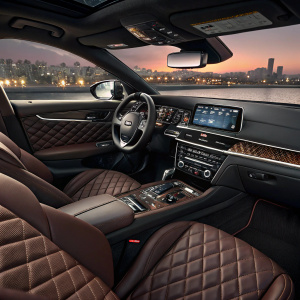 Sleek and modern interior of a 2023 Kia Optima SX. Dark brown quilted leather seats and a high-tech digital dashboard.
