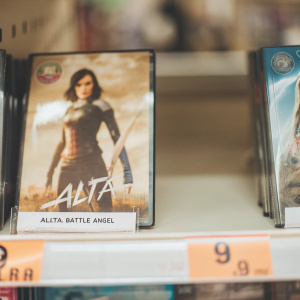 Two DVD cases of Alita: Battle Angel on a white backdrop. Movie protagonist standing confidently. Price tags on bottom left corner.