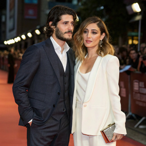 Yon Gonzalez and Blanca Suarez at the Madrid premiere of 'Perdiendo el Norte'. Yon in dark grey suit, Blanca in white ensemble with clutch. Blurred audience in background.