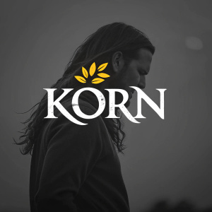 Digital artwork featuring Korn's logo. The word 'Korn' in sleek, white font. Against a dark background. Small, vibrant yellow highlights above the text. Modern and impactful design.