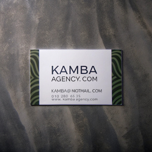 Business card for KAMBA AGENCY.COM, modern and minimalist design. White background with subtle green zebra pattern at bottom. Includes email: kAMBA@notmail.com, phone: 010 280 6535, website: www.kAMBA-agency.com. Clean, professional layout featuring abstract pattern.