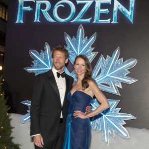 Jenson Button and Louise Griffiths attending the London premiere of 'Frozen'. They pose elegantly in front of the movie's glowing snowflake logo.
