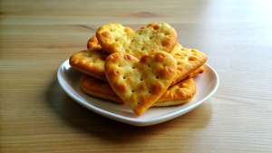 cheese crackers heart shape, on a plate, on a table side view