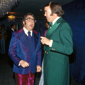 Ronnie Corbett and Egon Ronay in formal wear at a glitzy awards ceremony. They are engaged in animated conversation.