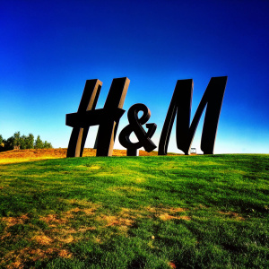 Bold, modern H&M logo design. Black geometric shapes intertwine with text in angular style. Against white backdrop.